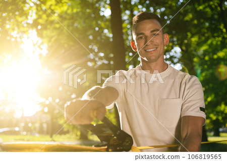 Young smiling man in the forest practising slacklining Young smiling man in the forest practising slacklining 106819565