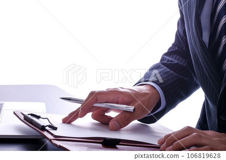 A man in a suit seriously checking documents A man in a suit seriously checking documents 106819628