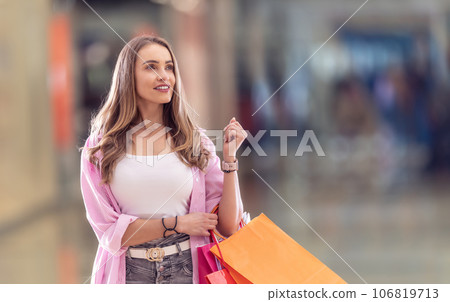 Attractive young woman with shopping bags in shopping mall 106819713