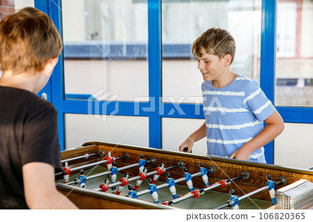 Two smiling school boys playing table soccer. Happy excited children having fun with family game with siblings or friends. Positive preteen kids or teenager. Two smiling school boys playing table soccer. Happy excited children having fun with family game with siblings or friends. Positive preteen kids or teenager. 106820365