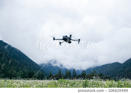 Flying drone in high altitude mountains Flying drone in high altitude mountains 106820499