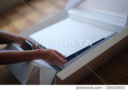 Tbilisi, Georgia - May 25, 2022: Woman removes white protective film from New iMac monitor Tbilisi, Georgia - May 25, 2022: Woman removes white protective film from New iMac monitor 106820883