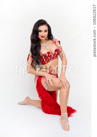 Bright beautiful brunette woman in dancing clothes on a white background, studio photo shoot 106822617