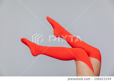 women's slender legs in stockings of red color on a white background 106823244