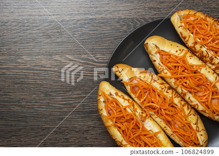 Tasty hot dogs on a black plate on a wooden background. Top view, copy space Tasty hot dogs on a black plate on a wooden background. Top view, copy space 106824899