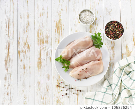 Raw chicken fillet with spices and herbs on a wooden table, top view 106826294