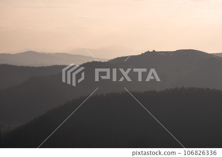 Golden sunset in mountain landscape. Layers of mountains background. Silhouette of the evening mountains at sunset. Golden sunset in mountain landscape. Layers of mountains background. Silhouette of the evening mountains at sunset. 106826336