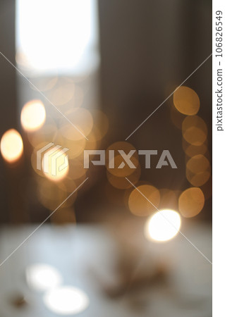 blur defocused abstract background. holiday, illumination and decoration concept - bokeh of christmas garland lights over beige home interior background blur defocused abstract background. holiday, illumination and decoration concept - bokeh of christmas garland lights over beige home interior background 106826549