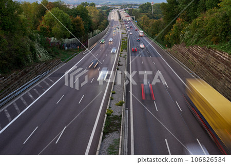 Long exposure photo of traffic with blurred traces from cars, top view. road, cars, blurred traffic, evening, top view. Highway at evening, blue hour illuminated by the traffic of cars Long exposure photo of traffic with blurred traces from cars, top view. road, cars, blurred traffic, evening, top view. Highway at evening, blue hour illuminated by the traffic of cars 106826584
