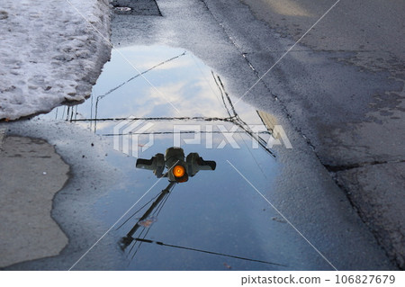 融化的雪水坑里倒映著交通燈 106827679