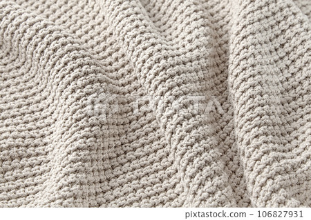 The texture of a large knitted gray sweater folded in waves. High quality background for design and layout The texture of a large knitted gray sweater folded in waves. High quality background for design and layout 106827931