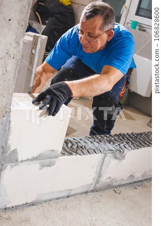Happy smiling construction worker constructing or building wall by placing bricks and cement - concept of hard working, manual labour and daily wagers lifestyle Happy smiling construction worker constructing or building wall by placing bricks and cement - concept of hard working, manual labour and daily wagers lifestyle 106828600