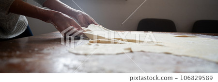 Female hands pulling homemade pastry dough for strudel 106829589