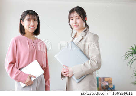 Two business women with devices_1 106829611