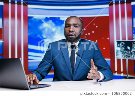 Journalist transmissing live content on media segment, using latest headlines to create reportage newscast for television network. Presenter host reading informations in newsroom. 106830062