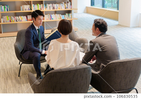 Businessman explaining to a couple Businessman explaining to a couple 106830535
