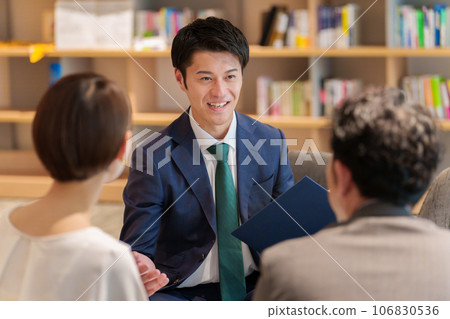 Businessman explaining to a couple Businessman explaining to a couple 106830536