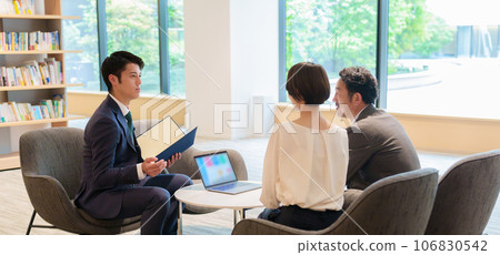 Businessman explaining to a couple Businessman explaining to a couple 106830542