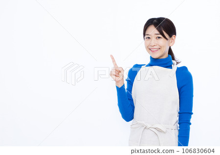 一位三十多歲的家庭主婦在白色背景前舉起食指 106830604