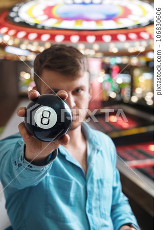 Man shows ball with number to camera. Lucky number or winning lottery. Numerology and divination Man shows ball with number to camera. Lucky number or winning lottery. Numerology and divination 106830606