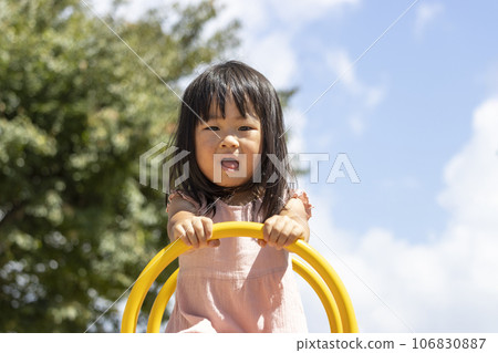 A girl playing with a seesaw while being scared (3 years old, Japanese) 106830887