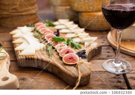 Slices of goat cheese with figs and red wine for tasting 106832380