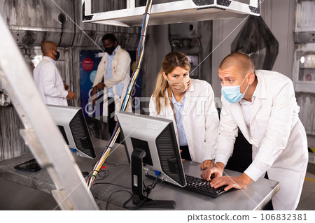 Friends in protective masks trying to solve conundrum in quest room in view as abandoned lab Friends in protective masks trying to solve conundrum in quest room in view as abandoned lab 106832381