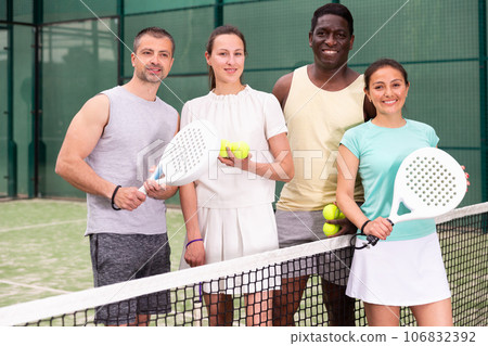 Cheerful team of men and women after playing padel on tennis court 106832392