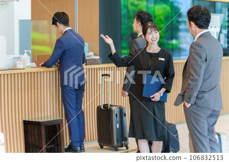 Female staff guiding guests at a hotel Female staff guiding guests at a hotel 106832513