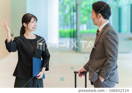 Female staff guiding men 106832514