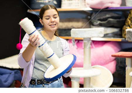 Young woman choosing cat scratching post for cats in pet shop Young woman choosing cat scratching post for cats in pet shop 106832786