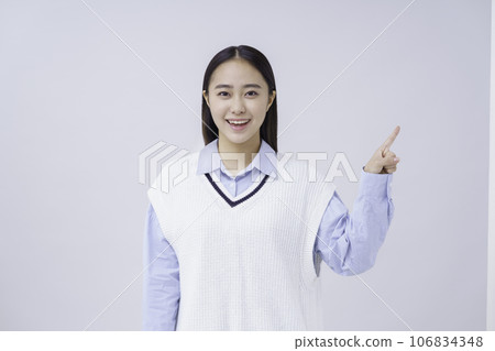 Portrait of a female student in a pointing pose against a white background Portrait of a female student in a pointing pose against a white background 106834348