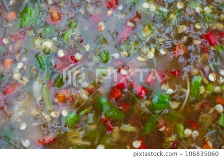 Full frame shot of Thai seafood dipping sauce. It is a green-colored sauce that comes from its main ingredients (green chilis and some herbs) with the bits of chili and garlic flakes. Full frame shot of Thai seafood dipping sauce. It is a green-colored sauce that comes from its main ingredients (green chilis and some herbs) with the bits of chili and garlic flakes. 106835060