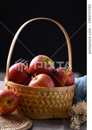 Red apples fruit in basket with black background 106835560
