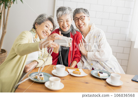 Senior women taking pictures at a cafe Senior women taking pictures at a cafe 106836568