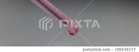 Glass pipette with purple liquid and drop on gray background. 106836577