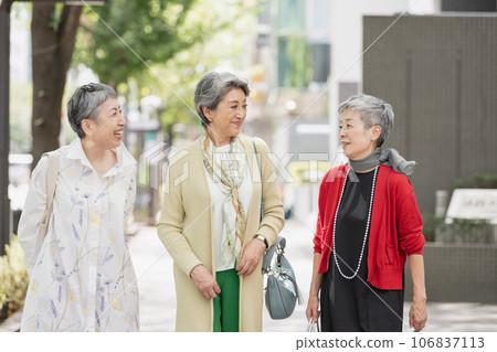 A senior woman with gray hair walking around town in style 106837113