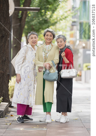 A senior woman with gray hair walking around town in style 106837118