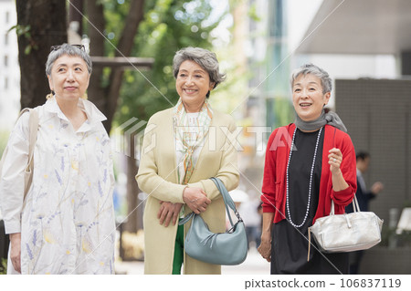一位頭髮花白的老婦人在城裡時尚地走來走去 一位頭髮花白的老婦人在城裡時尚地走來走去 106837119