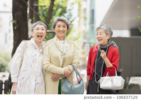 A senior woman with gray hair walking around town in style 106837120