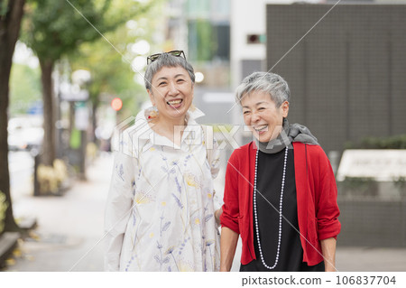 A senior woman with gray hair walking around town in style 106837704