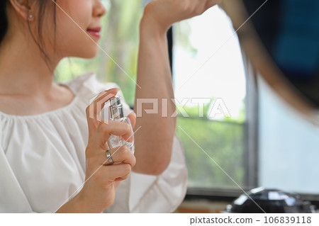 Young woman beauty blogger spraying perfume on her wrist while recording video and giving advices for her followers 106839118