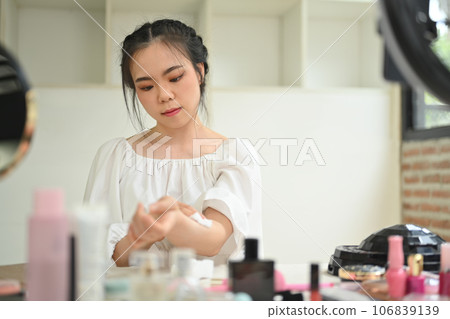 Cute young woman beauty make up artist or vlogger recording makeup tutorial in home studio. Lifestyle, influencer, blogger concept Cute young woman beauty make up artist or vlogger recording makeup tutorial in home studio. Lifestyle, influencer, blogger concept 106839139