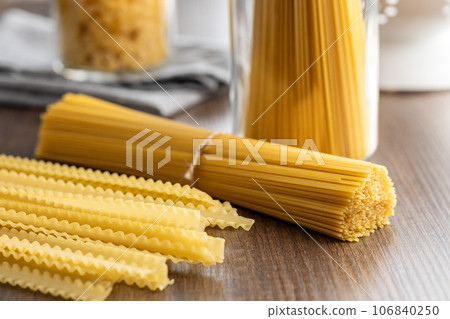 Spaghetti and mafaldine pasta. Uncooked italian pasta on wooden table. Spaghetti and mafaldine pasta. Uncooked italian pasta on wooden table. 106840250