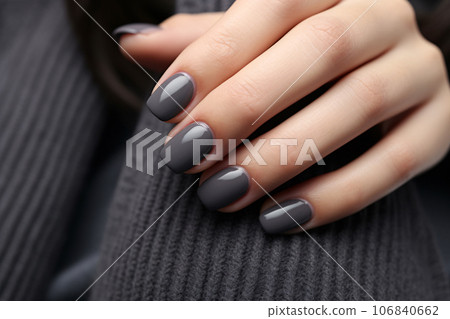 Closeup woman hand with dark gray and black nail polish on fingernails. Nail manicure with gel polish at luxury beauty salon. French manicure. Nail art and design. Female hand model. Generative AI. 106840662