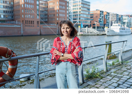 Mature smiling woman in embroidered shirt looking at camera, outdoor Mature smiling woman in embroidered shirt looking at camera, outdoor 106841098