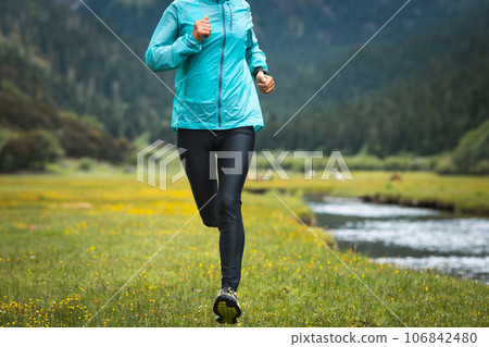 Woman trail runner cross country running in beautiful nature Woman trail runner cross country running in beautiful nature 106842480