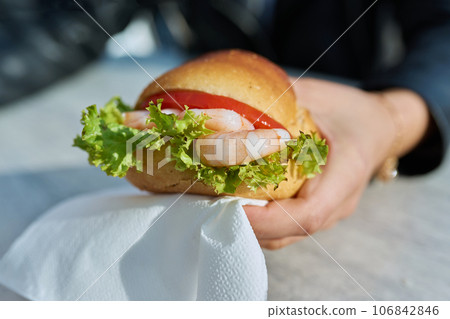 Traditional street sea food, shrimp burger, close-up in outdoor hands 106842846