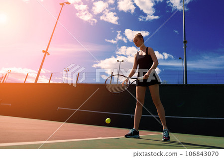Young woman is playing tennis on the court. 106843070