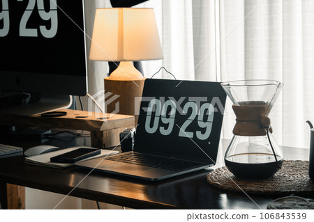 Home computer desk and digital clock on screen 106843539
